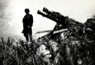 War and Conflict, World War II, pic: May 1940, A German soldier stands guard over a captured Dutch gun on the island of Texel, Germany invaded Belgium, Holland and Luxembourg in May 1940 claiming justification because they feared that the Allies, (France and Germany) had planned to use the Low Countries as a springboard for an attack on the Ruhr (Photo by Popperfoto/Getty Images)